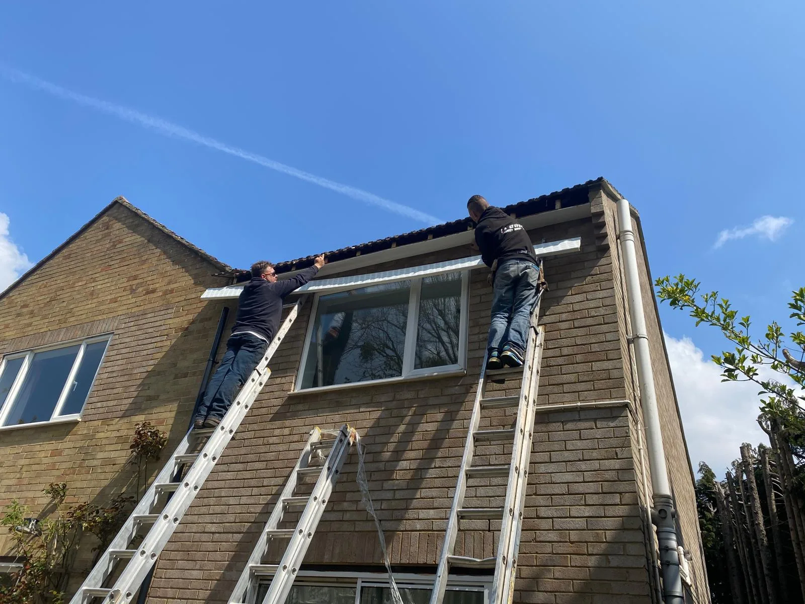 Roofers at work on a house in Hook